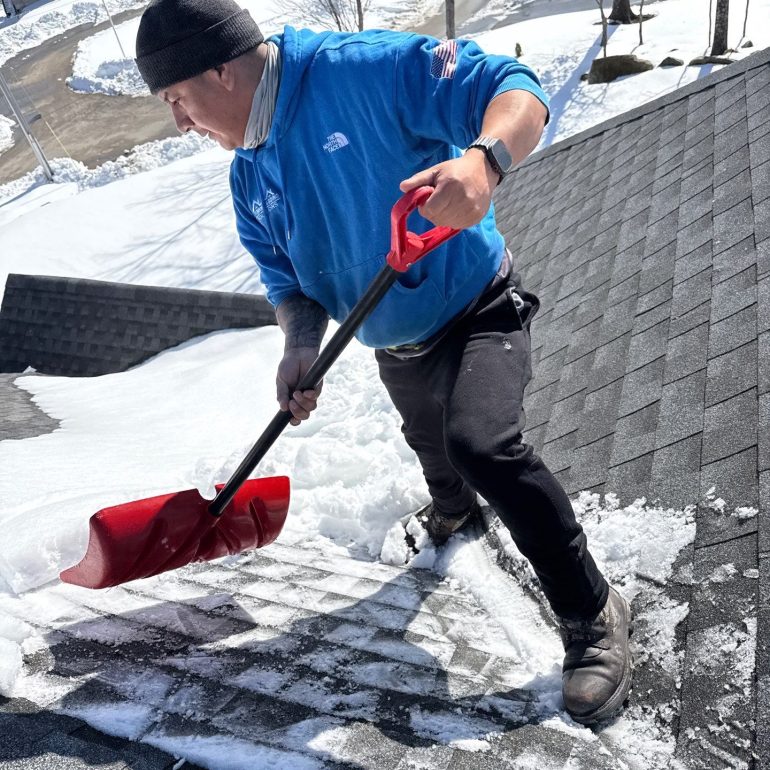 roof leak repair common causes winter roof maintenance Contractor removing snow from asphalt shingle roof to prevent roof leaks during winter